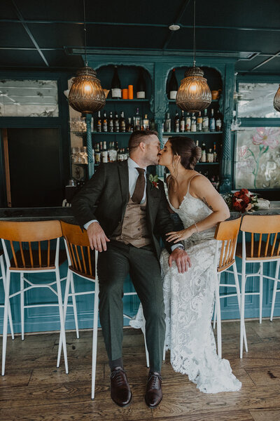 Bride and Groom kiss at bar