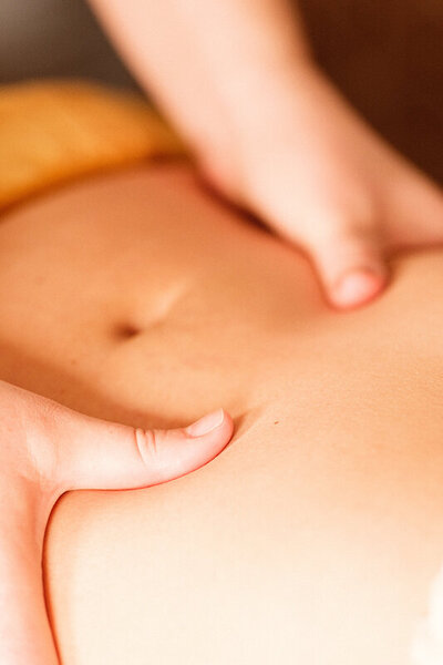 Gros plan sur mains massant en ventre lors d'un massage ayurvédique à challans en Vendée.