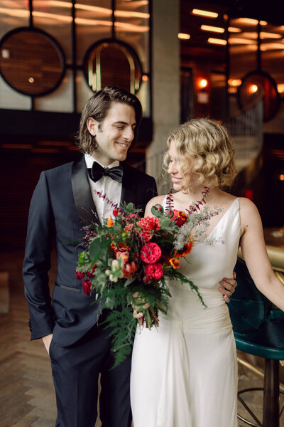 Bride and groom sharing a joyful moment in their suite at a Williamsburg, Brooklyn hotel during their New York City wedding.