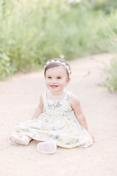 Toddler girl smiles for photo in floral dress