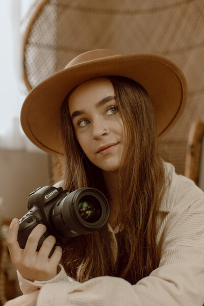 Boho photographer smiling while holding camera