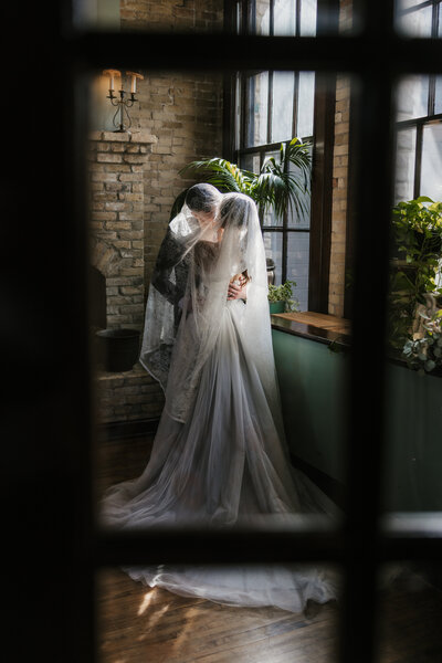 a groom kissing his bride on the head