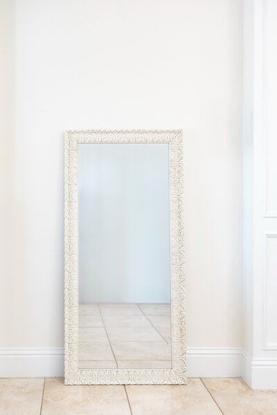 White beaded frame mirror on black easel stand