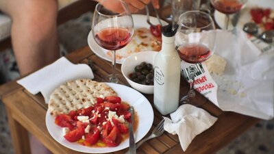 Photo of wine glass surrounded by plates of food