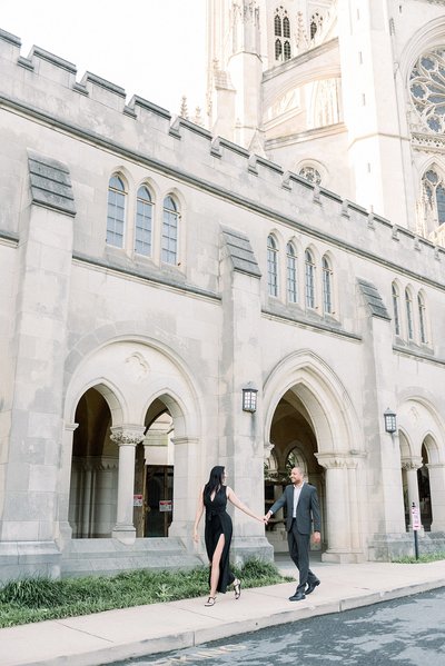 Couple walking holding hands in front of National Cathedral in Washington DC