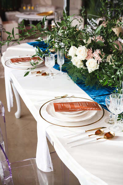 table place setting with plates, silverware, menu, and glass cups
