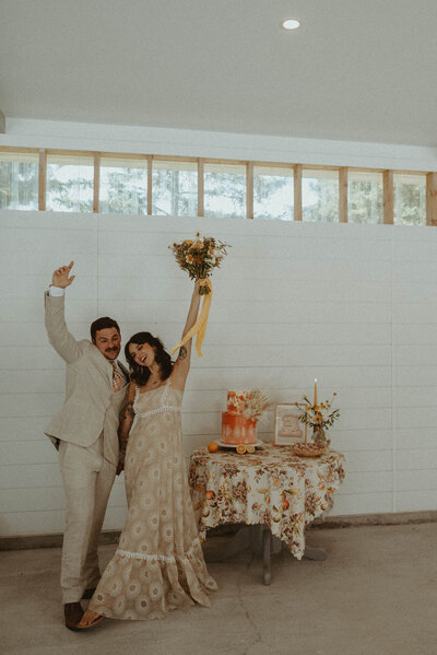 bride and groom beside wedding cake table