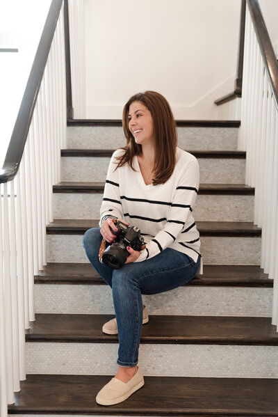 Female photographer on staircase holding camera