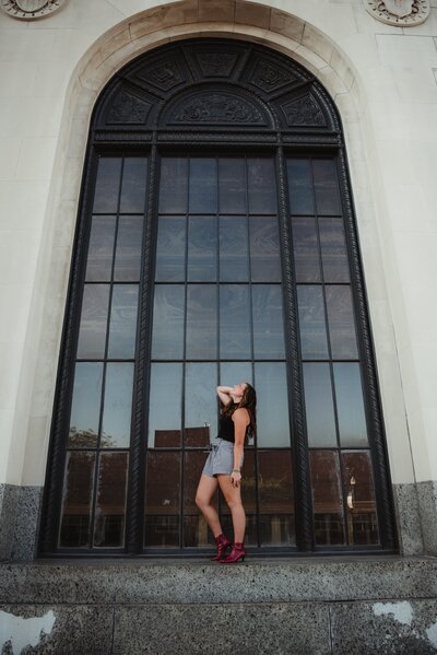 woman posing in front of modern building