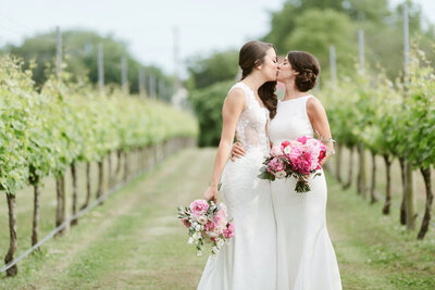 LGBTQ couple kissing at a vineyard on their wedding day