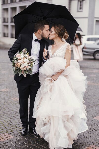 San Diego wedding  couple kissing in the street under an umbrella