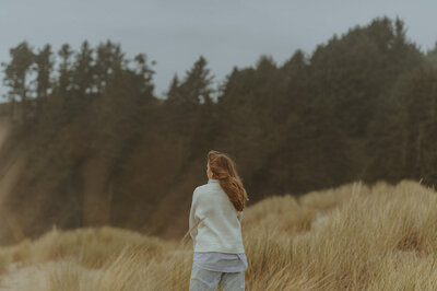 girl standing in sea grass at oregon coast