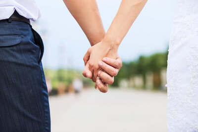 wedding-photo-of-married-couple-holding-hands-PMAPLSQ