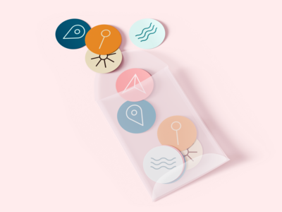 Colorful circular stickers spilling out of a clear bag onto a light pink surface