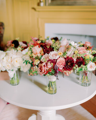 Floral arrangements in vases sitting on a round table 