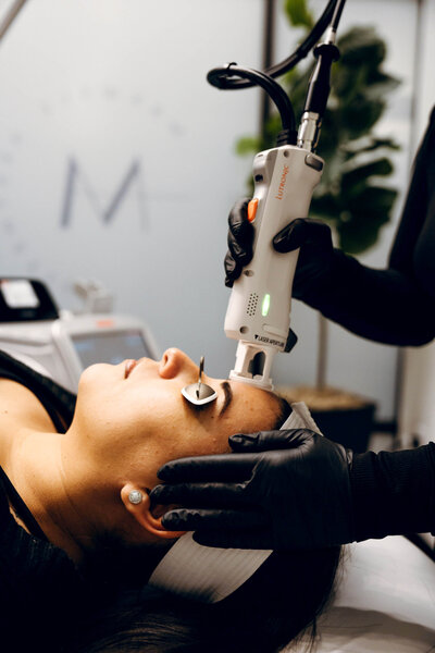 Provider explaining Botox or filler procedure to client in treatment chair at Maxwell Aesthetics in Salem, Oregon