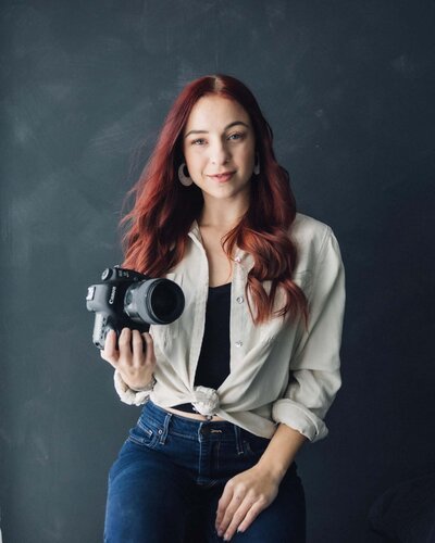 Female photographer posing with her camera