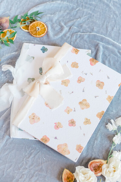 Elegant velvet scrapbook with ribbon, styled with flowers and flatlay decor for wedding guest messages.