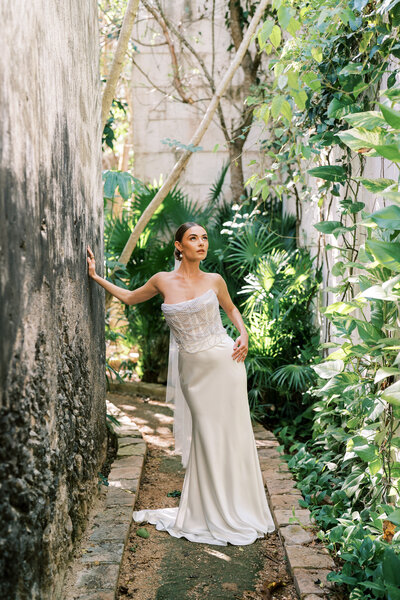 Stunning sophisticated bride takes bridal portrait in tropical pathway in Mexico