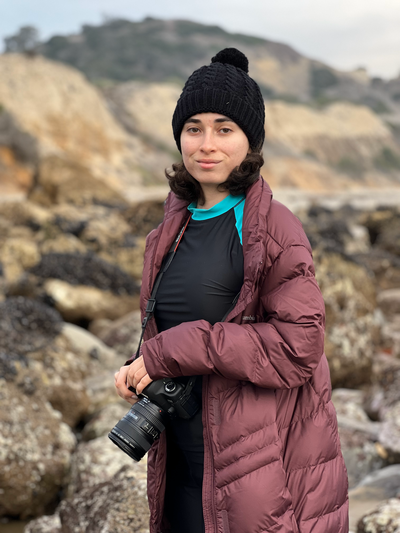 Woman photographer on a cold beach with her camera