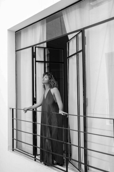 femme en robe debout sur un balcon
