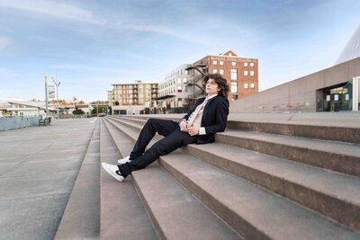 Tacoma Senior Grad Male sitting on stairs by museum of glass waterfront