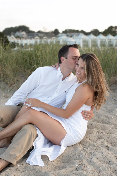 engagement and wedding photography, couple sitting on cape cod beach kissing