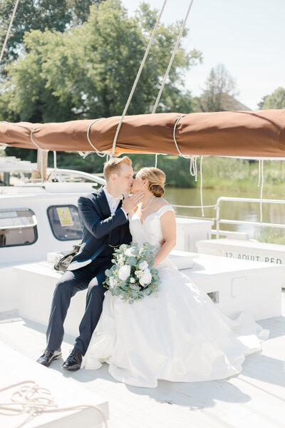 bride and groom on sailboat in st michaels maryland on wedding day by costola photography