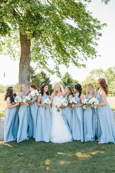 Bride wit her bridesmaids in light blue with white flowers