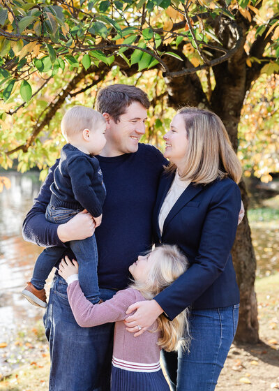 Lifestyle photo of hugging family an Essex County, New Jersey park in the fall.