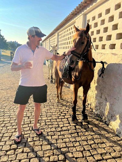 Happy clients enjoying a scenic moment with horses on a cobblestone path at a luxury estate in Portugal | theViatrix Portugal Custom Travel Planning