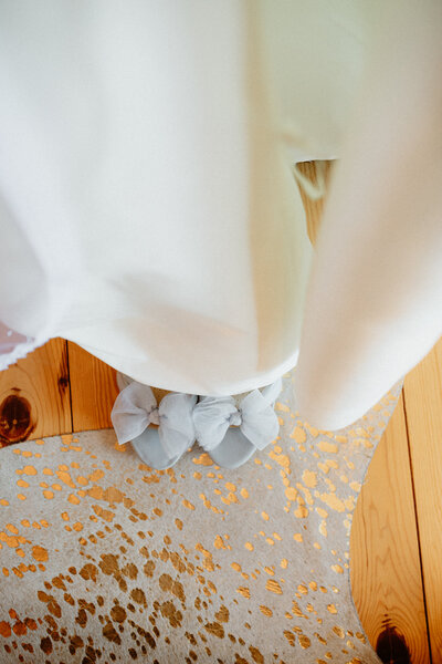 down view of a wedding dress with a focus on the shoes
