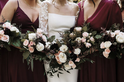Bride with bridesmaid posing with their flowers