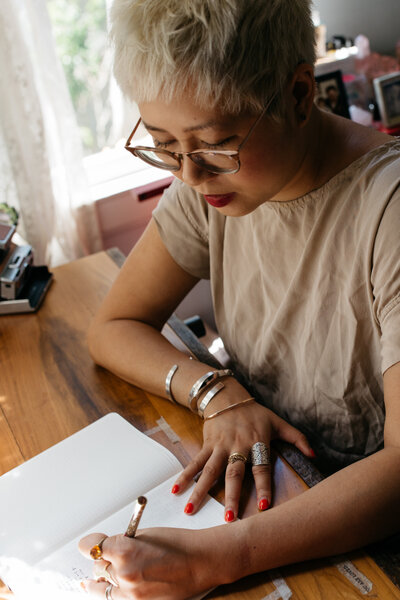 Esmé Weijun Wang, a blond Taiwanese American looking down and writing