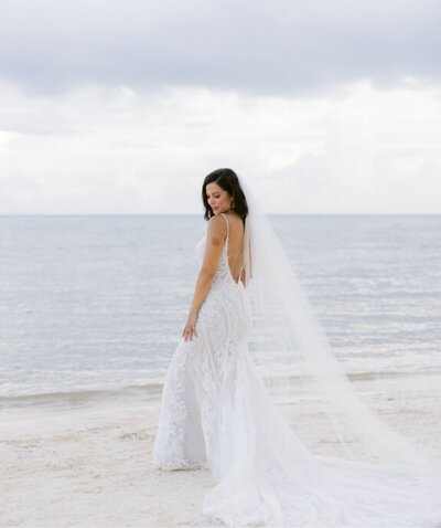 Bride posing on the beach before her tropical destination wedding