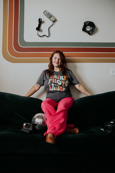 woman sits on vintage couch with camera in arizona