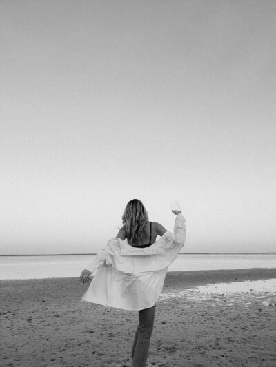 woman on the beach with a glass of wine