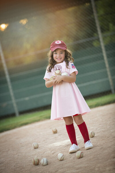 Cute girl on baseball field in league of their own dress