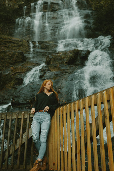 women standing in front of amicalola waterfall leaning on railing
