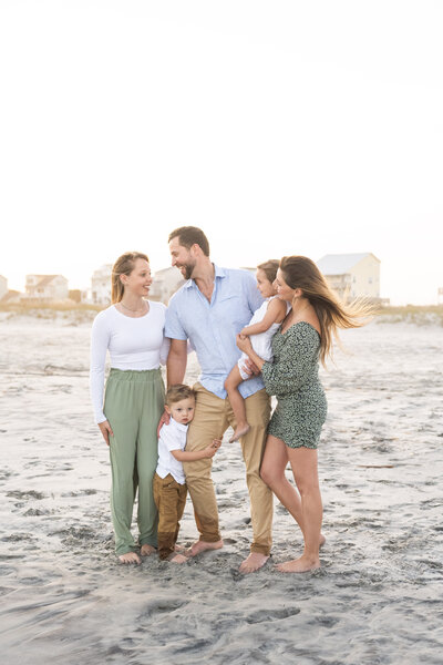 family of 5 standing on the beach during golden hour