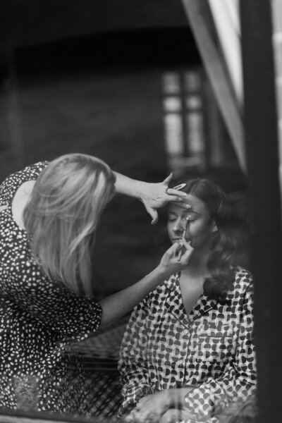 Kate Waller doing makeup on a bride, black and white