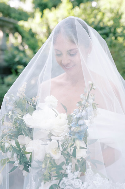 bride holding her bouquet with her veil over her at the Belmont
