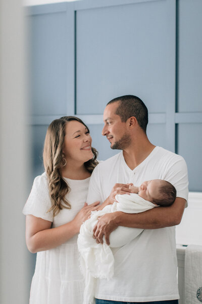 Couple holding baby in nursery