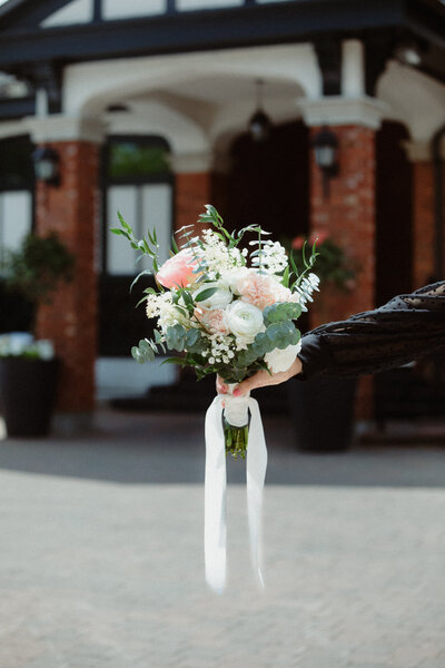 beautiful-bridal-bouquet-being-held-in-front-of-the-royal-ottawa-golf-club-in-aylmer