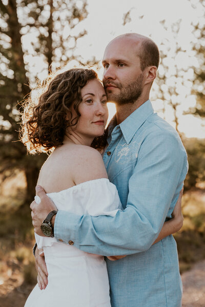 Newlywed couple embracing outdoors at golden hour in Nashville while the sun sets in the background