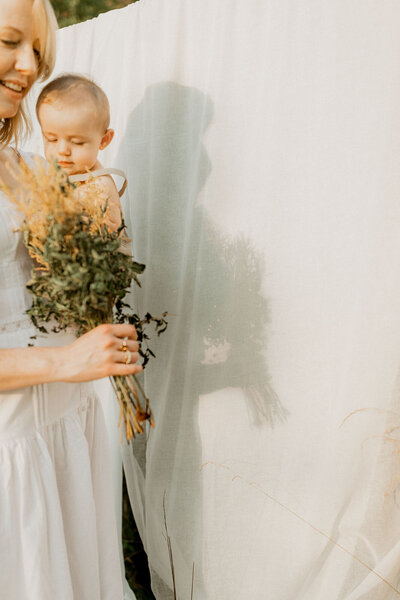 Mother holding child with yellow flowers