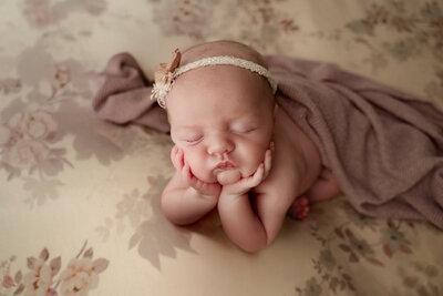 Baby girl posed on floral fabric for her newborn session in Dothan, AL