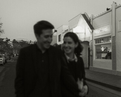 Blurry photo of couple walking down street and looking at each other smiling