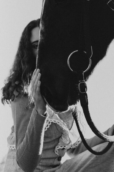 woman holding a horses face in her hand