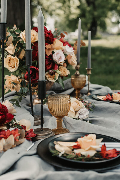 Table designed with plates, utensils, flowers and candle with stand